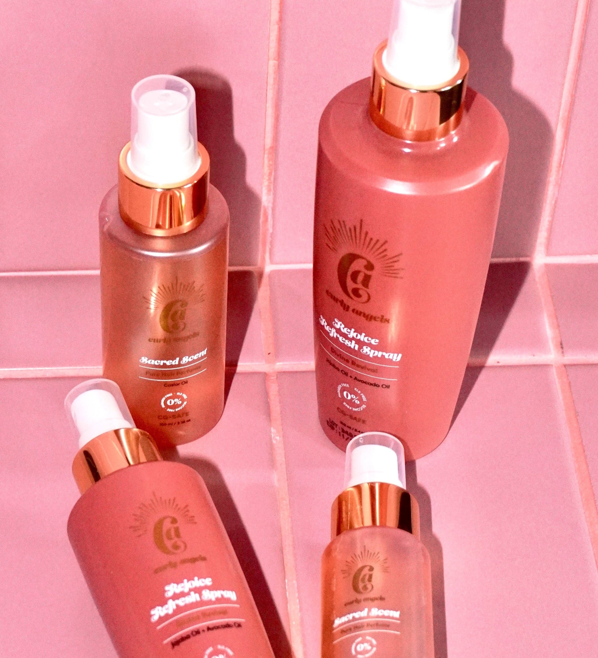 Curly Angels Rejoice Refresh Spray And Sacred Scent against pink tiles