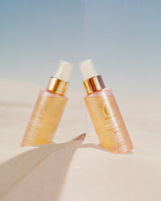 Curly Angels Sacred Scent Hair Mist on a mirror set in beach sand and clear blue sky - vegan - cruelty-free - Curly Girl Method Safe 