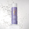 A bottle of vegan Salvation Conditioner by Curly Angel with a dynamic water splash in the background, deeply nourish and hydrate