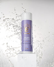 A bottle of vegan Salvation Conditioner by Curly Angel with a dynamic water splash in the background, deeply nourish and hydrate