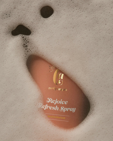 Curly Angels Rejoice Refresh Spray closeup peaking beneath foam