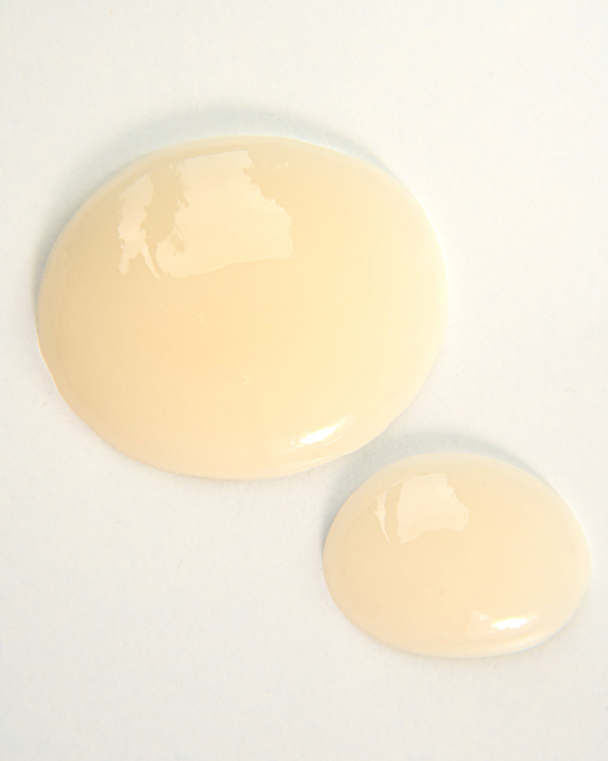 Curly Angels Holy Hold Styling Gel in two droplets on white background