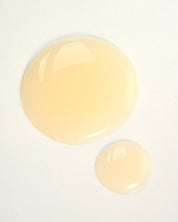 Two droplets of vegan Absolution Shampoo by Curly Angels on a white background 