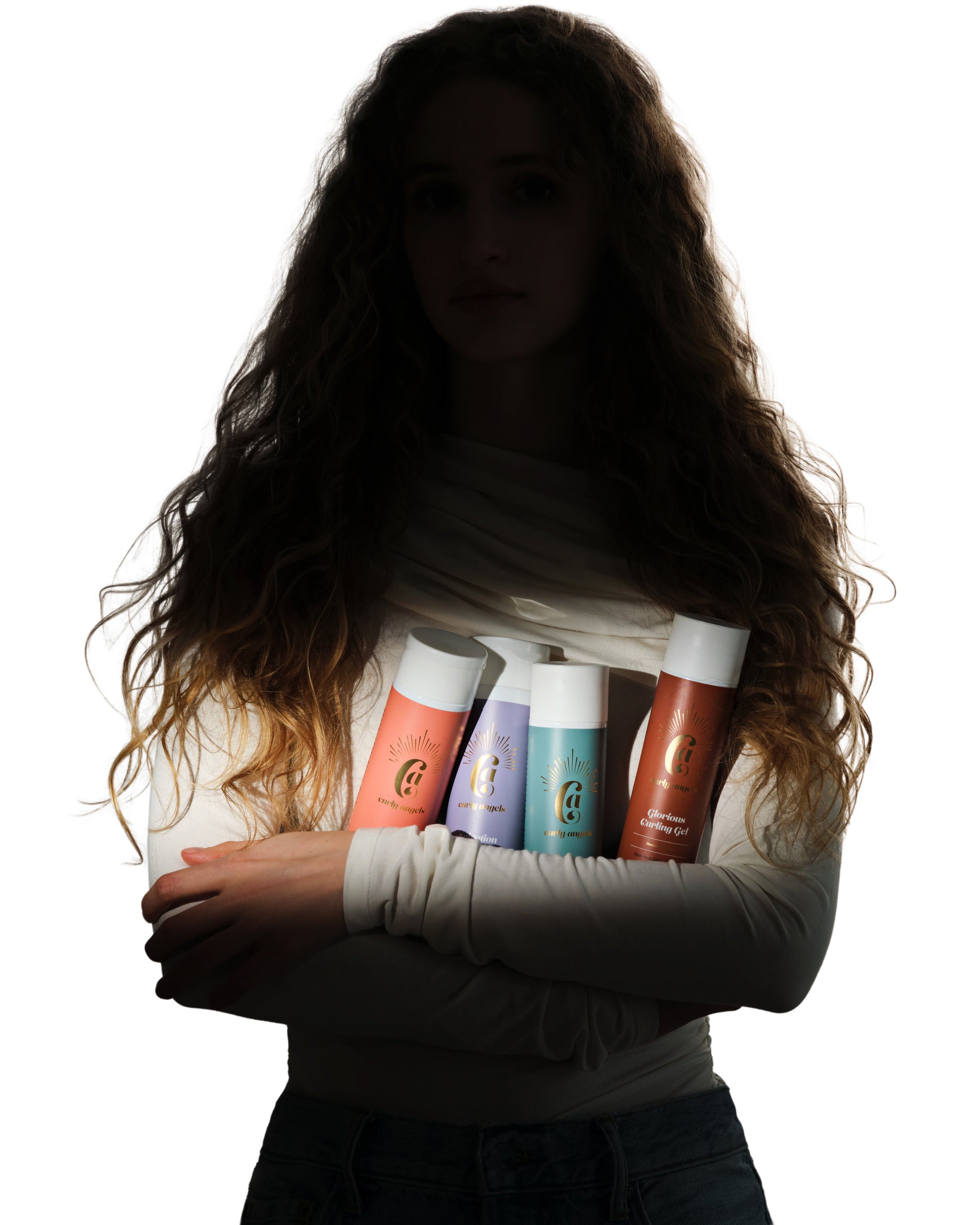Model in shadow holding the The Curly Angels Collection Set of four bottles including Absolution Shampoo, Salvation Shampoo, Conditioner, Hallelujah Curl Activator, and Glorious Curling Gel. All products are vegan, paraben-free, sulphate free and suitable for all curl types